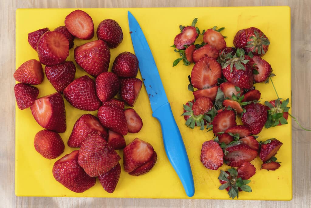 Cutting the tops off strawberries before freezing them